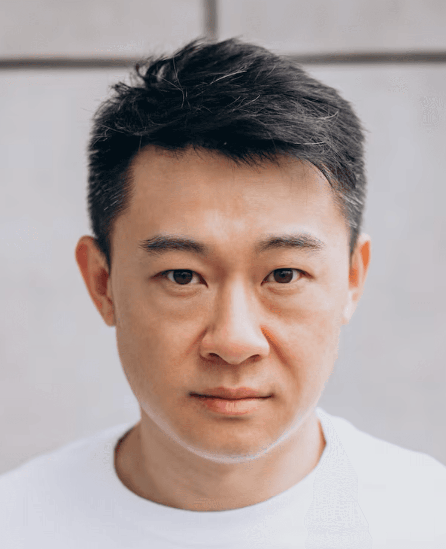 Close-up portrait of an East Asian man with short dark hair and a neutral expression.